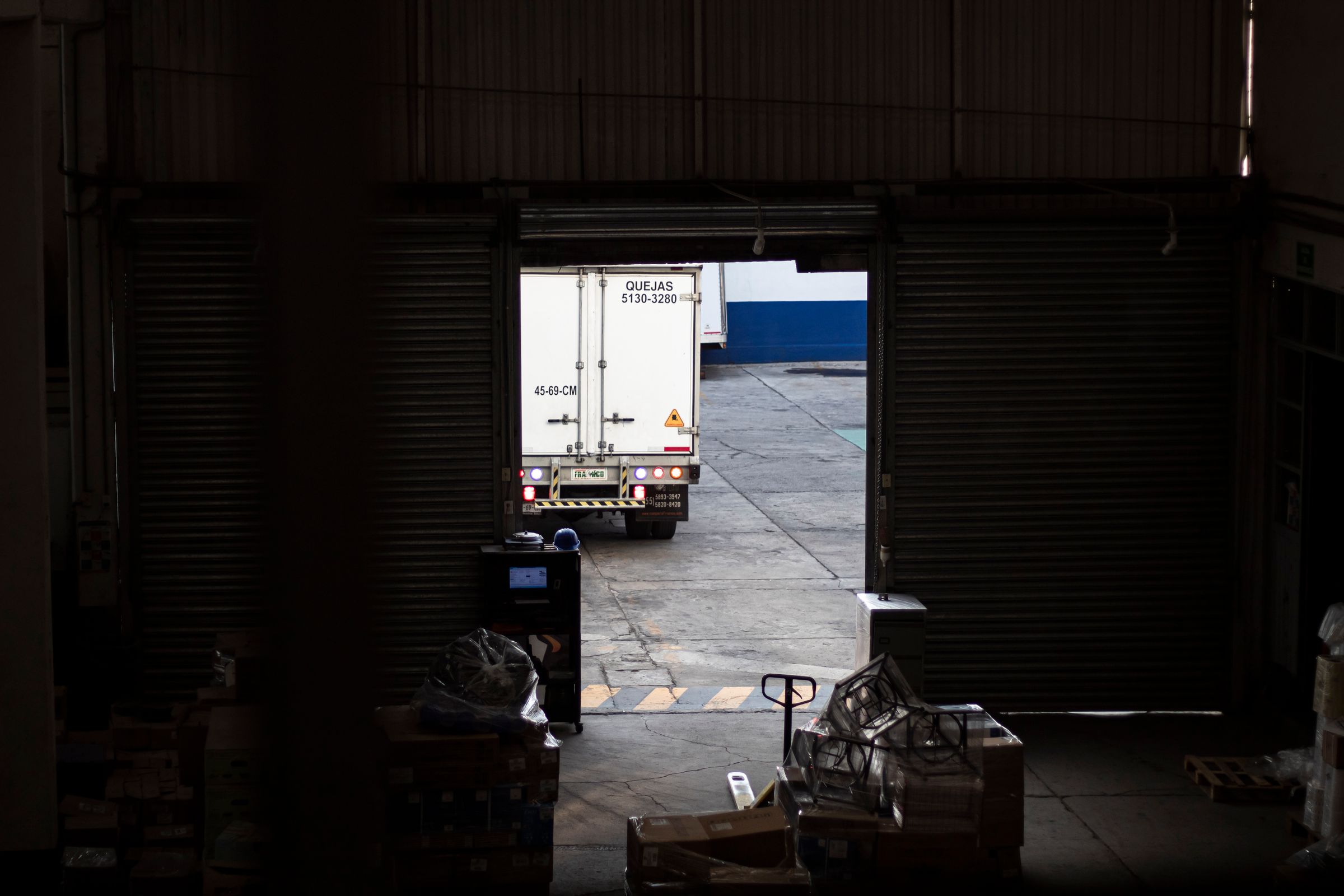 A refrigerated delivery truck leaving a logistics warehouse